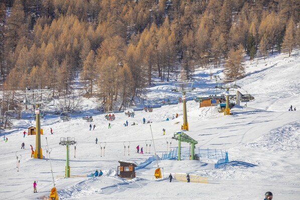 A ski resort with ski lifts, a chairlift, and a snowy landscape. - Genziana (Livigno)
