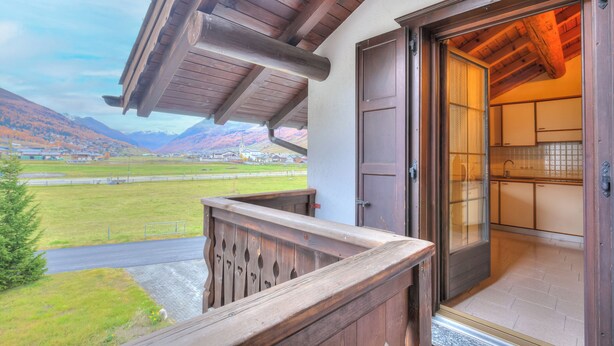 A wooden balcony with a view of a mountainous landscape. - Genziana (Livigno)