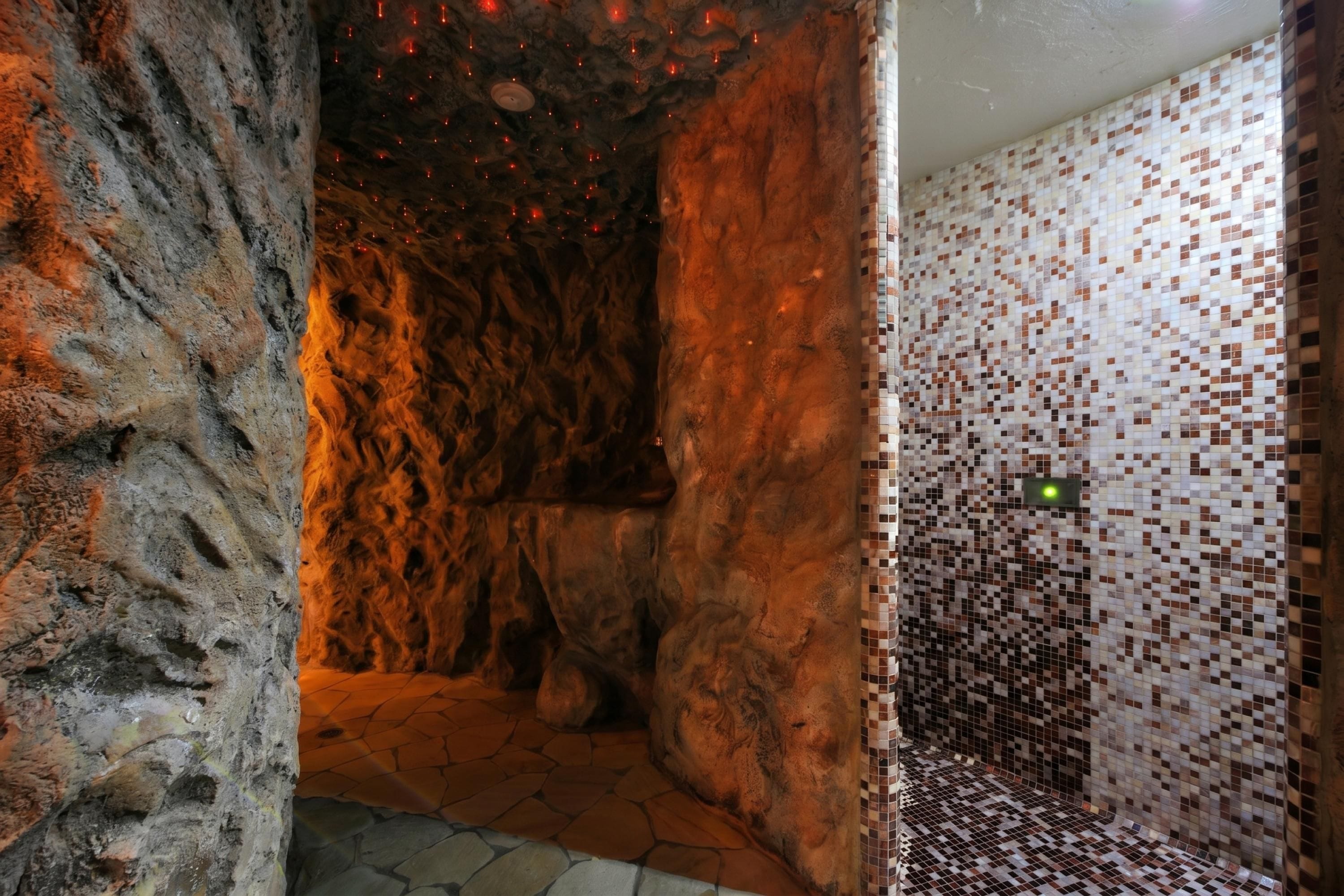 A spa area with a stone wall, a tiled floor, and a mosaic wall.