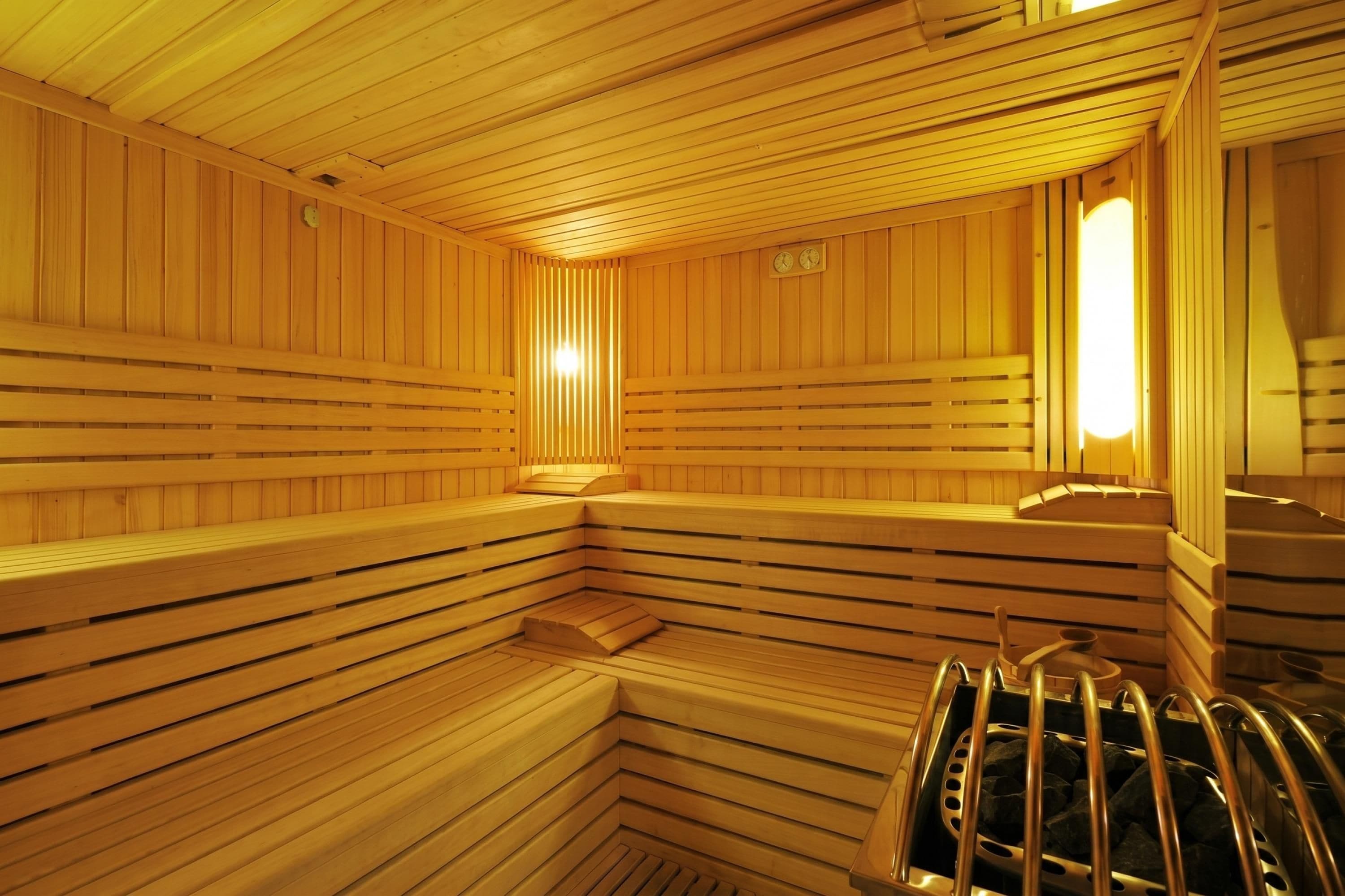 A sauna with wooden benches and a metal bench.