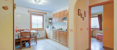 A kitchen with a dining table, cabinets, and a window.