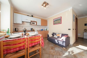 Een knus verblijf met een eethoek, kitchenette en een slaapbank.