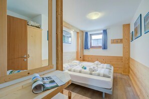 A room with a bed, a desk with a mirror, a wardrobe, and a window with curtains. - Italia 2 Ski in-Ski out 50m (Livigno)