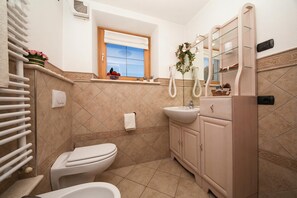 Une salle de bain équipée de toilettes, d’un lavabo et d’un meuble-lavabo.