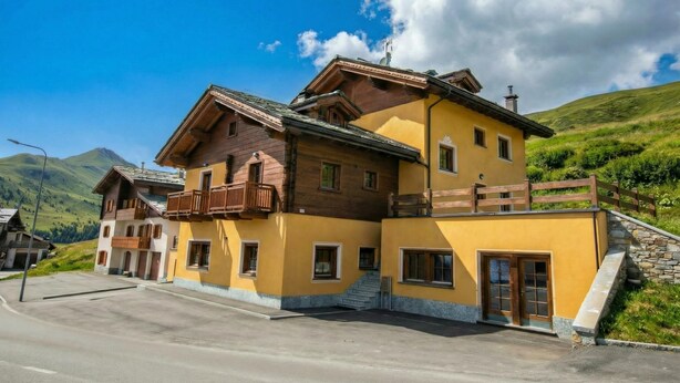 A two-story building with a balcony, a staircase, and a view of the surrounding landscape. - Sole Ski in- Ski out 50m (Livigno)