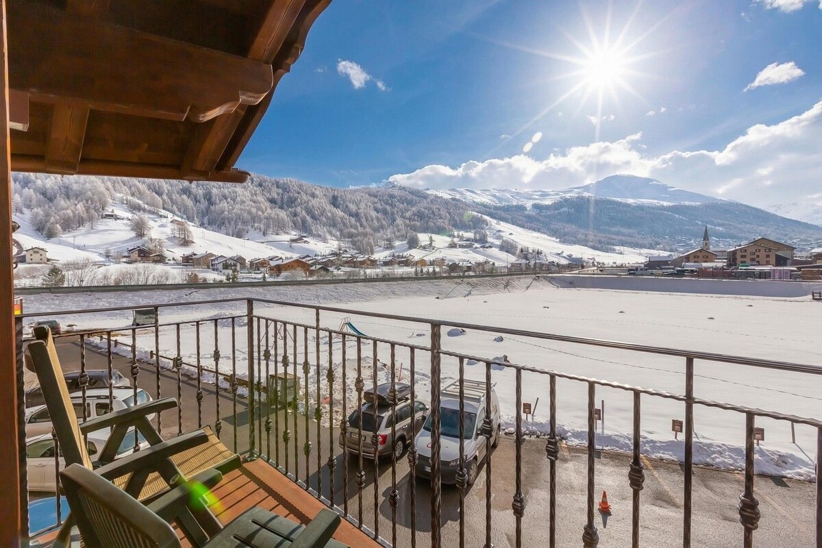 A balcony with a view of a snowy landscape and mountains.