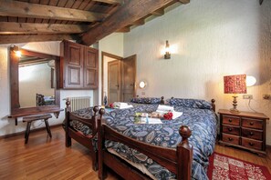 A bedroom with a wooden bed, a bench, a dresser, and a mirror.