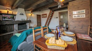 Un coin repas rustique, avec des meubles en bois, une cheminée et un téléviseur.