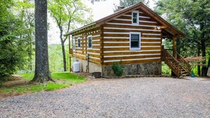 A log cabin with a stone foundation, a gravel driveway, and a wooden staircase leading to the entrance. - Touche' Too Cabin by Buffalo Mtn Getaway (Meadows of Dan)