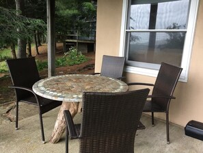 A round table with a mosaic top, surrounded by four wicker chairs, set on a concrete patio with a wooden post base. - Touche' Too Cabin by Buffalo Mtn Getaway (Meadows of Dan)