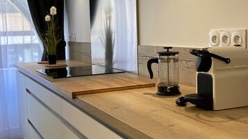 Una cucina moderna con cappa in acciaio inossidabile, forno a incasso e macchina da caffè.