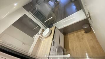 Casa de banho compacta com sanita, lavatório e zona de duche.