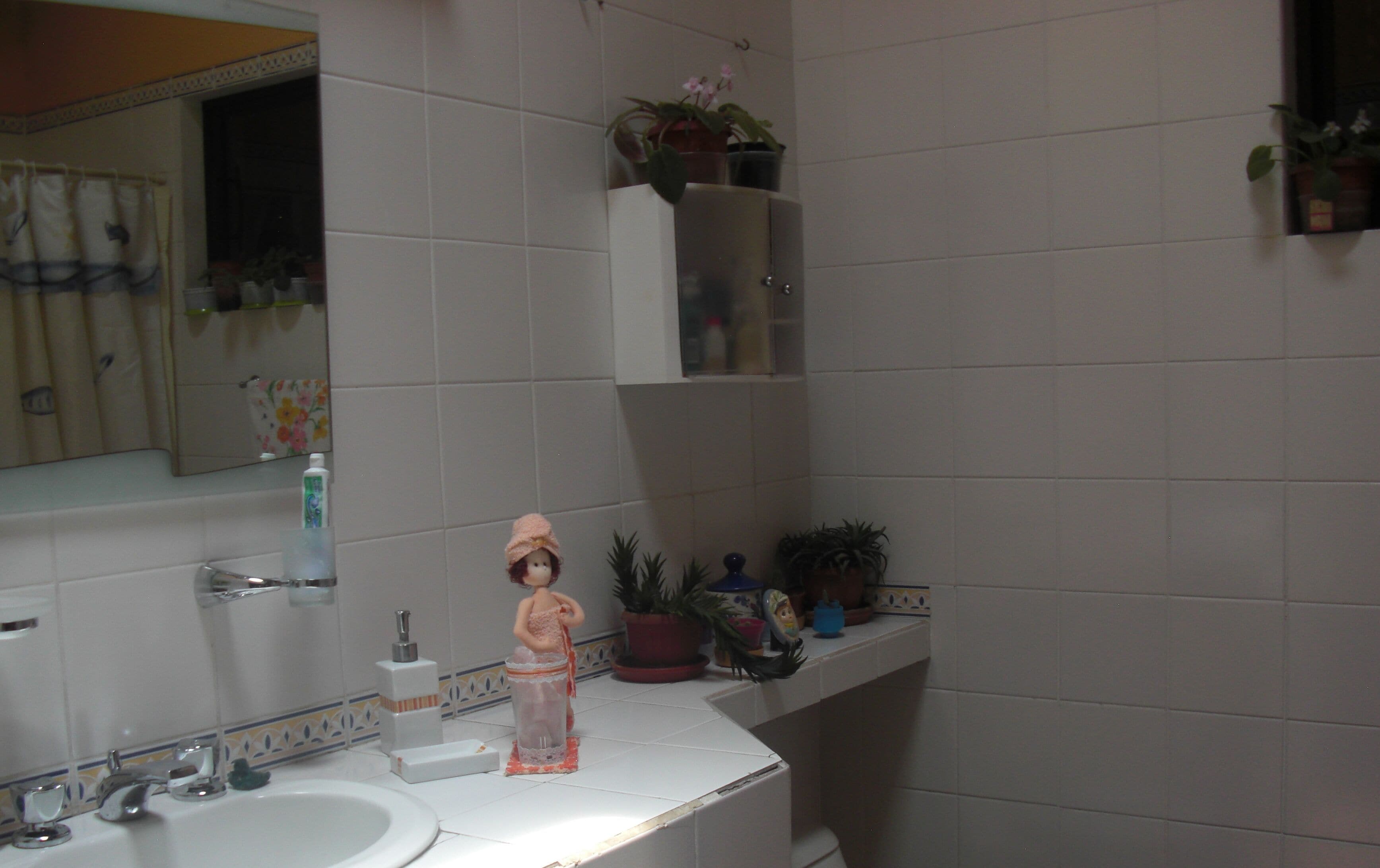 A bathroom with a sink, mirror, and various toiletries.