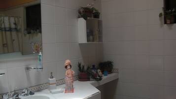 A bathroom with a sink, mirror, and various toiletries.