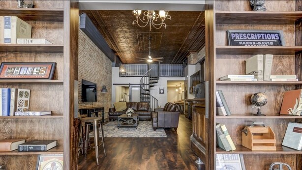 A spacious living area with a staircase, leather sofas, and a chandelier. - Lincoln’s Loft - Speakeasy Suite (Lincoln)