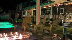 An outdoor patio area with a fire pit, seating, and a pool. - Beautiful Estate with salt water pool  & pond with kayaks  (Oak Bluffs)