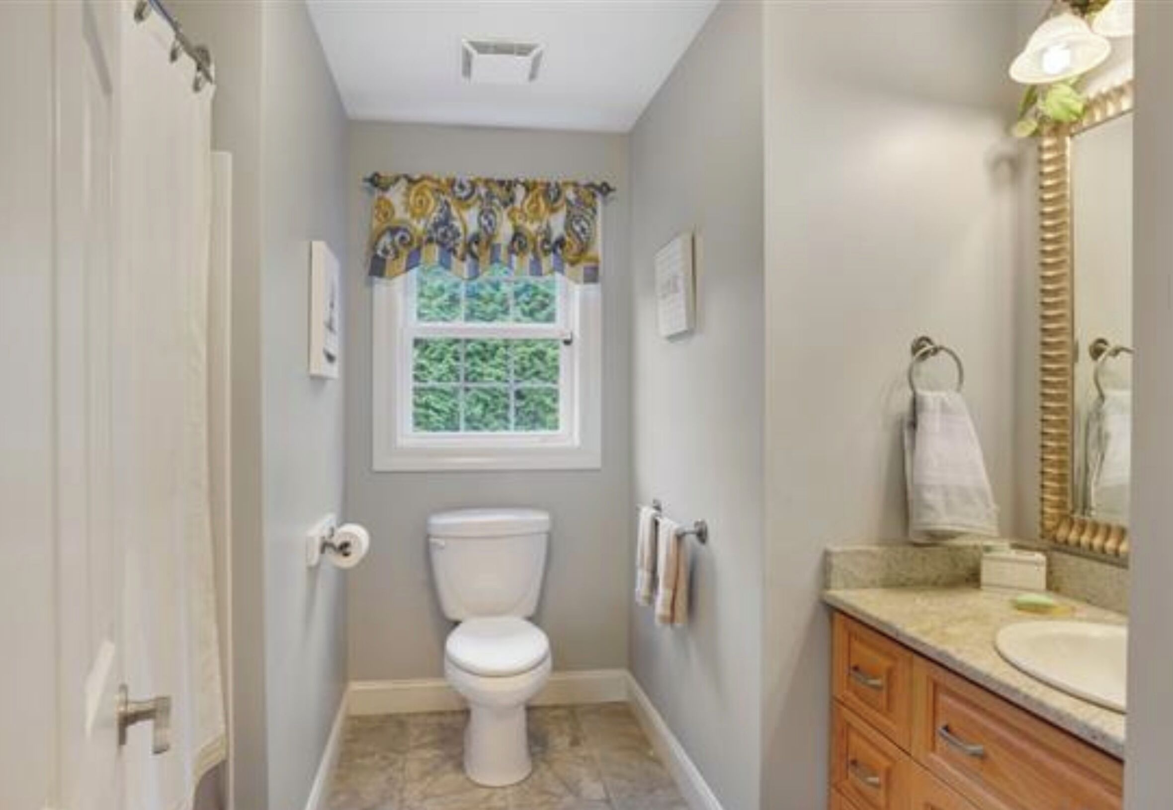 A bathroom with a toilet, a sink, and a mirror.