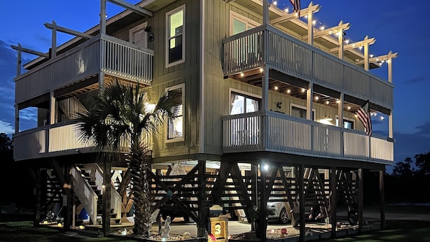 A multi-story house with a balcony and an American flag.