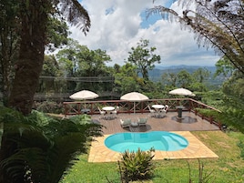 Una piscina al aire libre, sombrillas, tumbonas