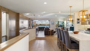 Cocina moderna con una isla central, asientos tipo barra y vistas al exterior.