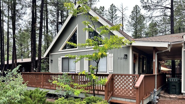 A cabin with a wooden deck, surrounded by a forest. - Moon Creek, A lovely Cabin that is located in the Pinetop Country Club Community (Pinetop)