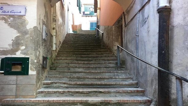 A set of stone steps leading up to a building entrance, with a metal handrail on the right. - Apartment in the heart of Cetara (Cetara)