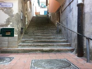 A set of stone steps leading up to a building entrance, with a metal handrail on the right. - Apartment in the heart of Cetara (Cetara)