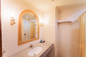A bathroom with a sink, mirror, and shower curtain.