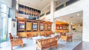 A spacious lobby with wooden furniture, a staircase, and a view of the outside.