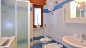 A bathroom with a bathtub, two toilets, a bidet, and a sink. - Appartamento a Capaccio ID 3338 (Licinella-Torre di Paestum)