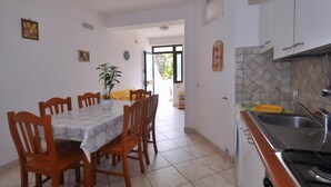 Un comedor con mesa y sillas, una cocina con fregadero y estufa, y vistas al exterior.