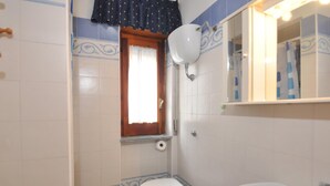 Un baño pequeño con inodoro, bidé y lavamanos.