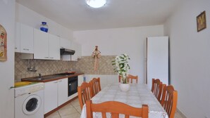 Una cocina compacta con lavadora, un lavamanos y una estufa.