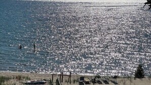 Una playa con un camino de madera que lleva a sillas y sombrillas.