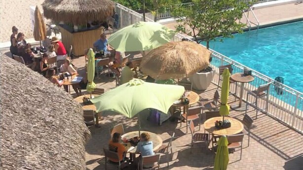A beachside resort with outdoor seating, a pool, and a thatched-roof hut. - Oceanfront condo, beach, pool. 4 eateries on premises. Rent kayaks and jet skis. (Fort Lauderdale)
