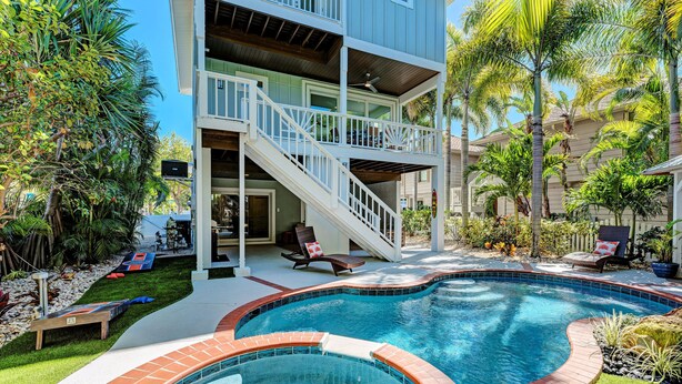 Une maison à deux étages dotée d’une piscine, d’un espace extérieur aménagé et d’un escalier menant à l’étage supérieur.