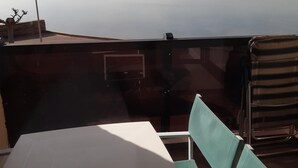 Una terraza con mesa y sillas que da a un cuerpo de agua tranquilo.