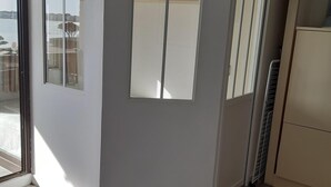 Una cocina moderna con paredes grises, una mesa de madera y una ventana con vistas a un balcón.