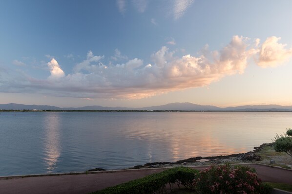 A calm lake with a clear sky and distant mountains. - TWO-BEDROOM APARTMENT WITH EXCEPTIONAL VIEWS OF THE LAKE AND THE CANIGOU (Le Barcarès)