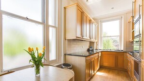 Eine moderne Küche mit Holzausstattung, einer schwarzen Arbeitsplatte und einem Fenster, das für natürliches Licht sorgt.