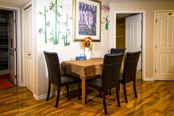Enjoy meals with family and friends in this dining area, featuring a table for four, comfortable chairs, and a beautiful floral arrangement.