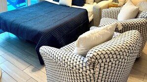 A bedroom with a bed, a sofa, a chair, a ceiling fan, and artwork on the wall. - Beautiful Beachfront 2 Bed/2 Bath Condo - Walk to Hangout and Great Rates (Gulf Shores)