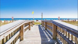 A wooden boardwalk leading to a beach with 'STAY OFF' signs and a yellow flag. - Beautiful Beachfront 2 Bed/2 Bath Condo - Walk to Hangout and Great Rates (Gulf Shores)