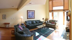 A living room with a sectional sofa, a patterned armchair, a coffee table, and a large painting on the wall. - Table Rock Lake, Steps to Marina (Holiday Island)
