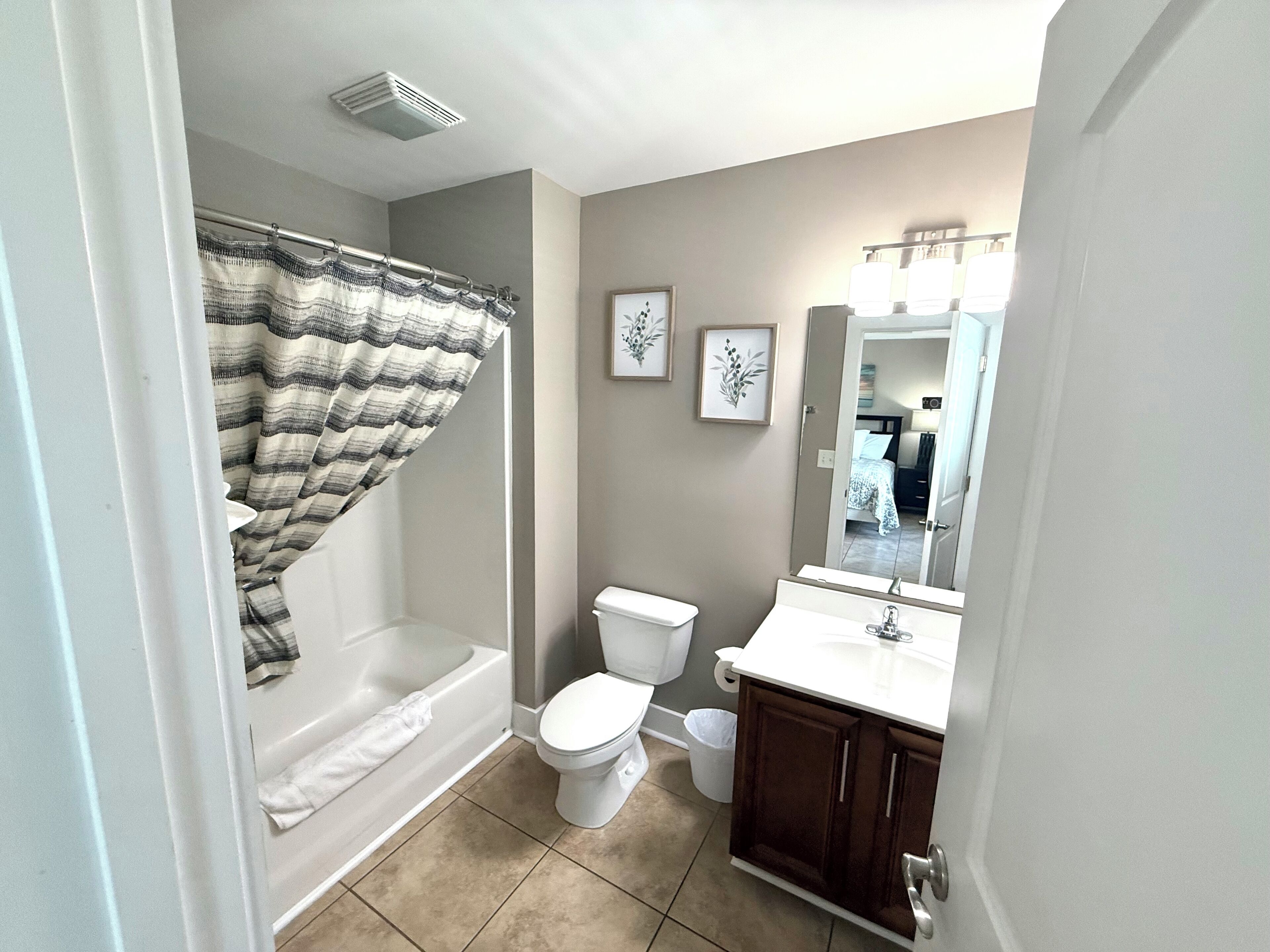 A bathroom with a bathtub, toilet, and vanity.