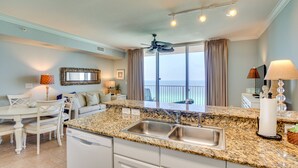 A kitchen with granite countertops, a built-in sink, and a ceiling fan.