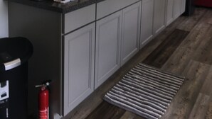 A modern kitchen with white cabinets, a stainless steel sink, and a window above the counter.