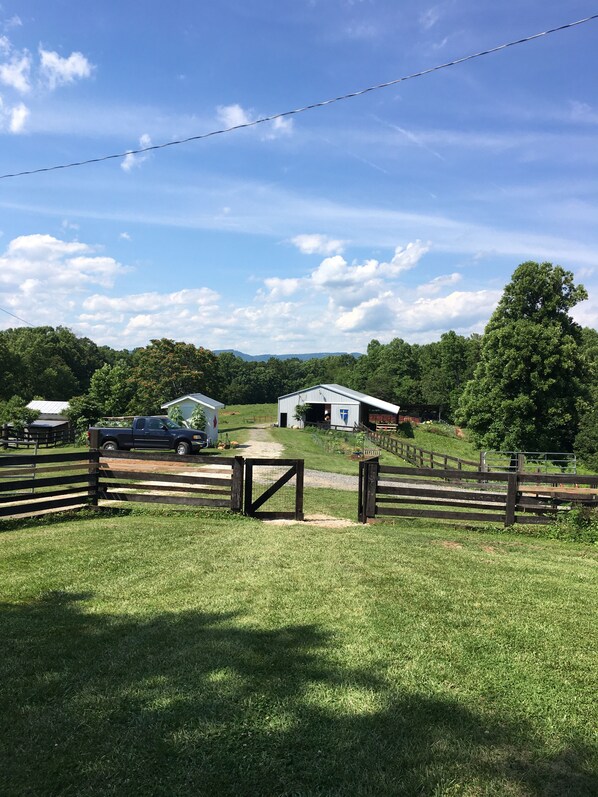 A rural landscape with a fenced area, a barn, and a truck parked near a gate. - The Ranch in Mt Airy (Mount Airy)
