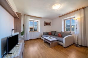 A modern living room with a sofa, a coffee table, a TV, and a floor lamp.