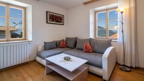 Una sala moderna con un sofá gris, una mesa de centro blanca y una lámpara de pie.